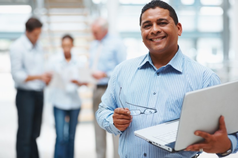 istock_000012181046_small Middle aged business man using laptop with executives in the background